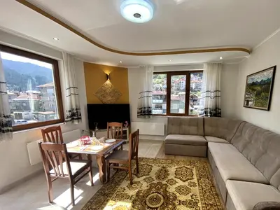 a living room with a couch and a table at Апартамент и Студио Перелик in Chepelare