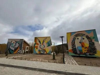 a group of three buildings with paintings on them at ЕКО Къщи Марциганица in Dobrostan