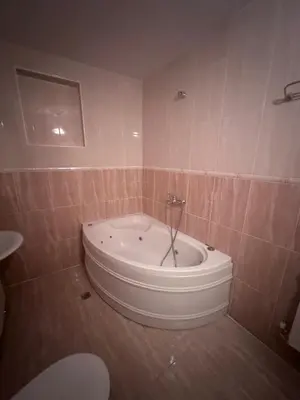 a bath tub in a bathroom with a toilet at Hotel MERIDA in Blagoevgrad