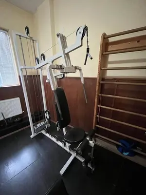 a gym room with a treadmill next to a bed at Hotel MERIDA in Blagoevgrad