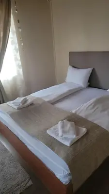 two beds sitting next to each other in a room at Стаи за гости Писателите in Hisarya