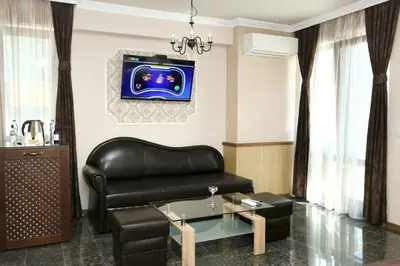 a living room with a leather couch and a table at Mon Ami Apart in Studentski Grad Area in Sofia
