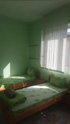 a room with two beds in a room with windows at Хотел Елит in Kostinbrod