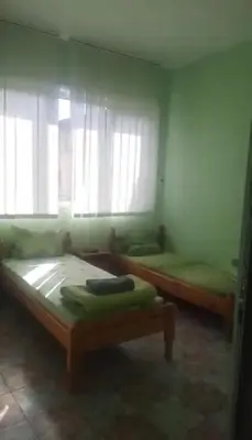 a bedroom with two beds and a window at Хотел Елит in Kostinbrod