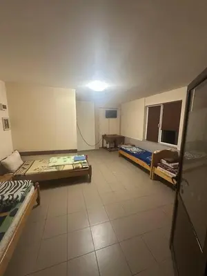 a room with two beds and a table in it at Хотел Елит in Kostinbrod