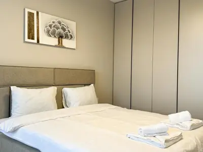 a bedroom with a bed with towels on it at Modern & Spacious Two-Bedroom Apartment in Plovdiv