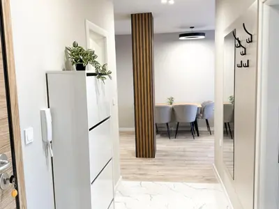 a hallway with a white refrigerator and a dining room at Modern & Spacious Two-Bedroom Apartment in Plovdiv