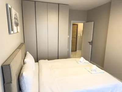 a bedroom with a large bed with white sheets at Modern & Spacious Two-Bedroom Apartment in Plovdiv