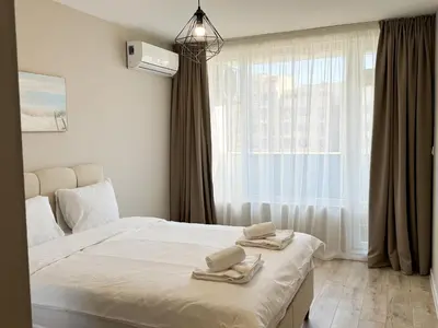a bedroom with a bed and a large window at Modern & Spacious Two-Bedroom Apartment in Plovdiv