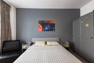 a bedroom with a bed and a chair at Space art apart in Sofia