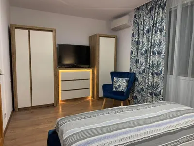 a bedroom with a bed and a tv and a chair at Tsvetanov Apartment in Blagoevgrad