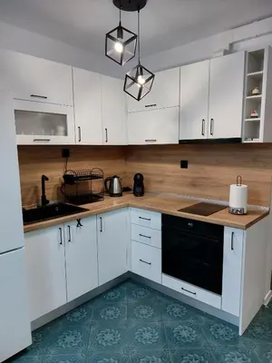a kitchen with white cabinets and a black dishwasher at Tsvetanov Apartment in Blagoevgrad