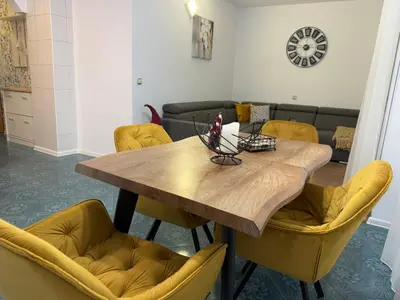 a dining room with a wooden table and yellow chairs at Tsvetanov Apartment in Blagoevgrad