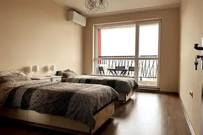 a bedroom with two beds and a large window at New apartment with a great view in Sofia