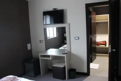 a bedroom with a desk and a tv on a wall at Guest House Veni in Blagoevgrad