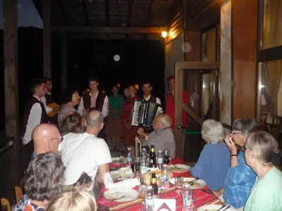 a group of people sitting around a table at a party at Ognyanovata Guest House in Dobărsko