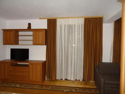 a living room with a large window with a television at Ognyanovata Guest House in Dobărsko
