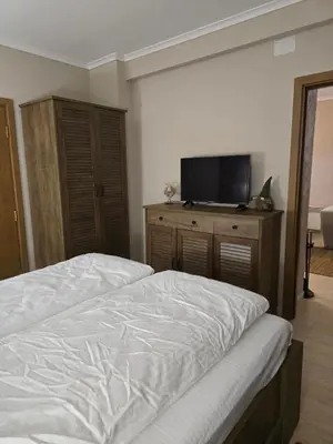a bedroom with a bed and a flat screen tv at Костадинов 2 in Pamporovo
