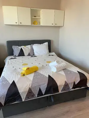 a bedroom with a bed with a comforter and pillows at Magnolia city view studio in Sofia