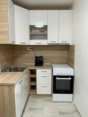 a kitchen with white cabinets and a sink and a stove at Magnolia city view studio in Sofia