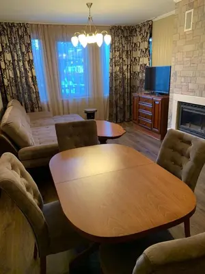 a living room with a table and a couch and a table and chairs at Костадинов 1 in Pamporovo