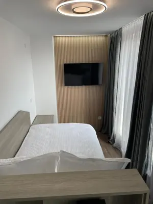 a bedroom with a bed and a flat screen tv at Flat Park Sandanski in Sandanski