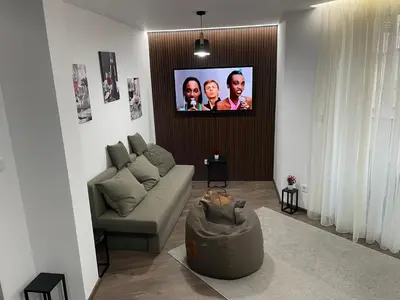 a living room with a couch and a flat screen tv at Flat Park Sandanski in Sandanski