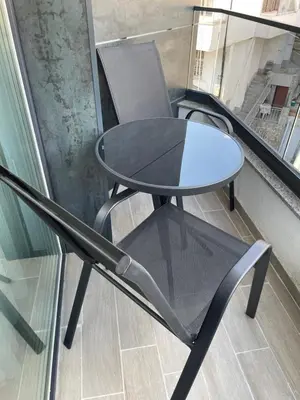 a table and chair in a room with a window at Flat Park Sandanski in Sandanski