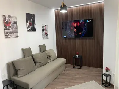 a living room with a couch and a tv at Flat Park Sandanski in Sandanski
