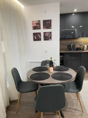 a table in a room with chairs and a kitchen at Flat Park Sandanski in Sandanski