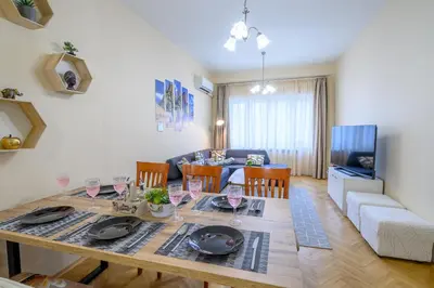 a dining room and living room with a table and chairs at Grand Luxury Condo by NDK and National Stadium with Free Parking in Sofia