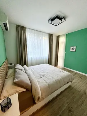 a bedroom with a large bed with a green wall at Downtown Gem in Plovdiv