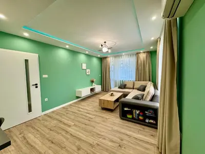 a living room with green walls and a couch at Downtown Gem in Plovdiv