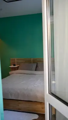 a bedroom with a bed with a green wall at Downtown Gem in Plovdiv
