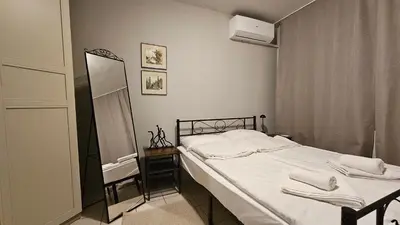 a bedroom with a bed with white sheets and a mirror at Colorful 2BD Apartment next to Serdika Center by Flat Mаnager in Sofia