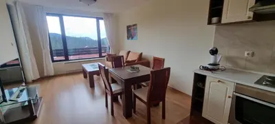 a kitchen and dining room with a table and chairs at Apartment Geronimo in Pamporovo