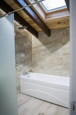 a bath tub in a bathroom with a skylight at Хотелски комплекс Релакс in Rudozem