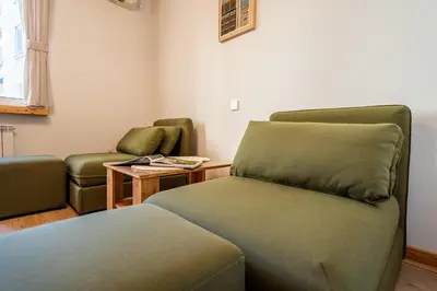 a room with two green chairs and a couch at A central retreat in the heart of Sofia in Sofia