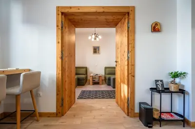 a wooden door leading into a living room with chairs at A central retreat in the heart of Sofia in Sofia