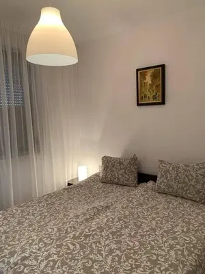 a bedroom with a bed and a lamp and a window at Elegant Two Bedroom Apartment - Top Location in Bansko