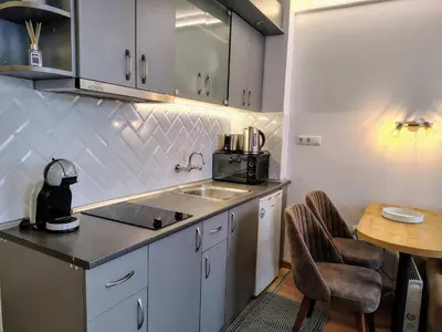 a kitchen with a counter and a sink and a table at Ski lift studio in Bansko