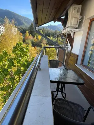 a balcony with a table and chairs on a house at Bansko soul relax place in Bansko