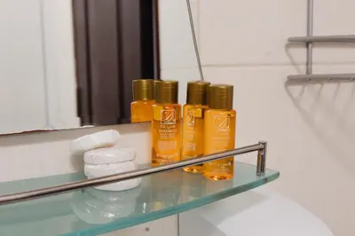 a shelf with four bottles of essential oils in front of a mirror at Pirin Peaks Residence - next to Ski Lift in Bansko