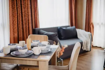 a living room with a table with cups and dishes on it at Rila Residence - next to Pirin Golf in Razlog