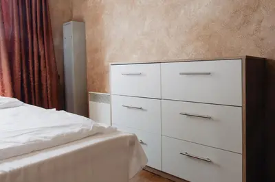 a bedroom with a white dresser next to a bed at Rila Residence - next to Pirin Golf in Razlog