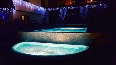 a large swimming pool with blue lights in a building at Villa Leventy in Banya