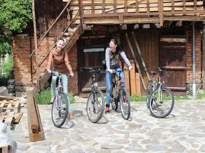 two people standing with their bikes in front of a building at Villa Leventy in Banya