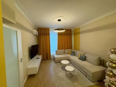 a living room with a couch and a tv at Homely Apartment in Lozenets Sofia in Sofia