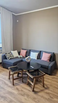 a living room with a blue couch and a table at Concrete comfort in Samokov