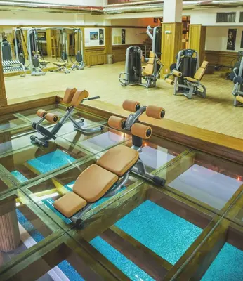 a gym with a glass floor with chairs in it at FEDORA - Luxury Penthouse in Pirin Golf & SPA in Razlog
